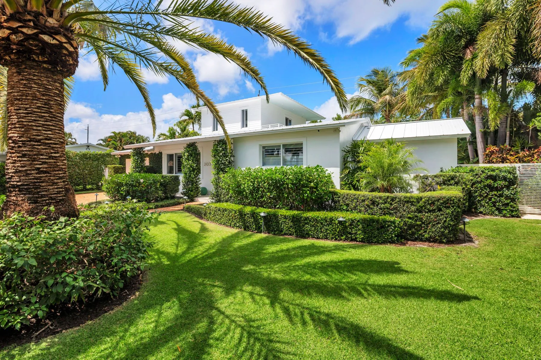 Front of property — landscape, hedges, gated entry
